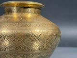 a gold vase that is sitting on a table