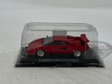 a red toy car in a glass case on a white surface