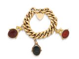 un gros plan sur un bracelet en or orné de pierres rouges et noires