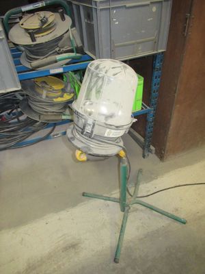 un ventilateur posé sur un trépied dans une pièce