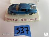 une petite voiture bleue en plastique exposée sur une table