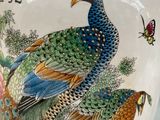 a vase with a bird on it sitting on a table