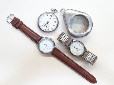 trois montres et une montre de poche posées sur une surface blanche