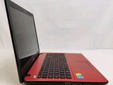 an open red laptop computer sitting on top of a white table