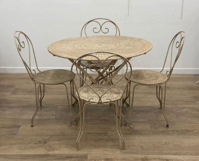 une table entourée de quatre chaises, posée sur un parquet