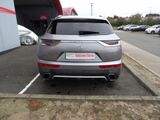 the rear end of a silver car parked in a parking lot