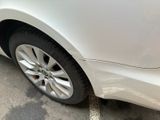 a white car parked in a parking lot with its door open