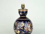 un vase bleu et or surmonté d'une lampe
