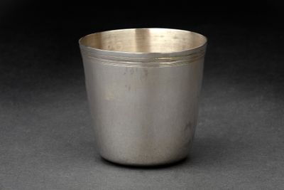 une vieille coupe en argent posée sur une surface noire