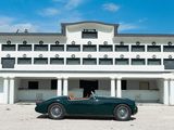 a green car parked in front of a large white building