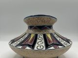 a vase that is sitting on a white surface