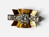 gros plan d'une bague en or et diamants sur une surface blanche