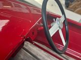 a steering wheel on a red car in a garage