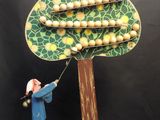 une figurine représentant un homme en train de couper une branche d'arbre avec un couteau