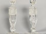 two clear glass candlesticks sitting on top of a white table