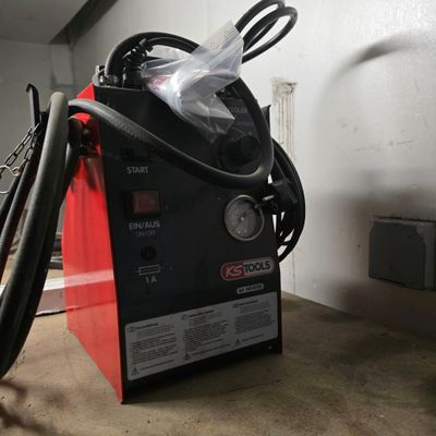 a machine that is sitting in a garage with a hose