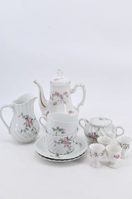 a white tea set with pink flowers on it