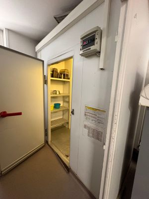 a small refrigerator in a small room with a door open