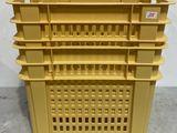 a close up of a stack of yellow plastic containers on a floor