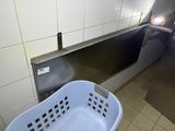 a blue laundry basket sitting in the corner of a public restroom