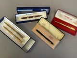 three pens and a pen in a box sitting on a table