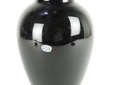 a black vase that is sitting on a white surface