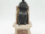 statue d'un homme assis sur un trône, avec une croix sur la tête
