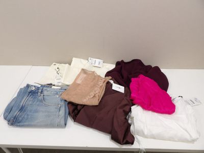 une table blanche sur laquelle sont posés de nombreux vêtements