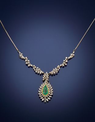 an emerald and diamond necklace on a blue background