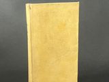 a yellow book sitting on top of a table next to a black background