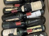 Les bouteilles de vin se trouvent dans un carton posé sur une table.
