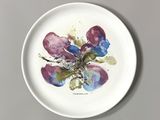 a white plate with a painting of flowers on it