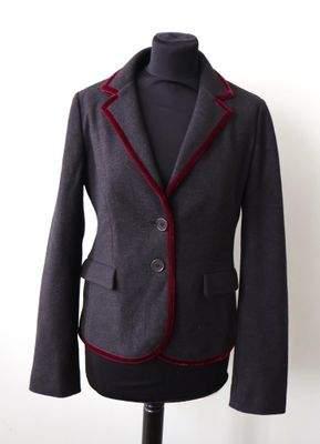 une veste posée sur un mannequin, avec un mur blanc en arrière-plan