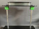 un gros plan d'une table en métal et en verre avec un piètement vert