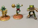five figurines of frogs that are standing on top of each other