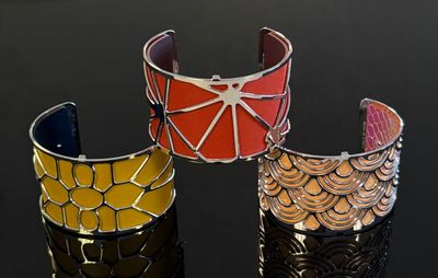 trois bracelets de couleur différente posés sur une surface noire