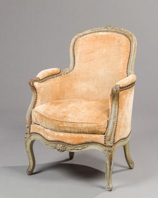 an old fashioned chair with a beige upholstered seat