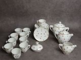 une image représentant un ensemble de tasses et soucoupes à thé et à café blanches et dorées