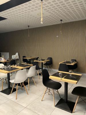 many tables and chairs in a restaurant with black and white chairs