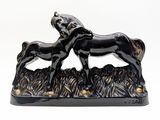 a black statue of a horse and a foal in the grass