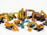 de nombreux engins de chantier miniatures posés sur une surface blanche