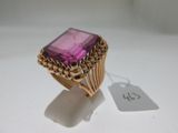 a close up of a ring with a pink stone on it