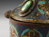 an old blue and gold box with a green stone in the top