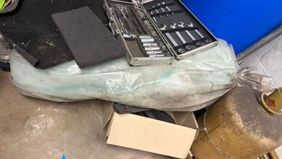 un tas d'outils divers posés par terre à côté d'une chaise bleue