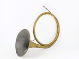 an old brass trumpet sitting on top of a white surface