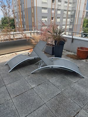 two lounge chairs on the roof of a building
