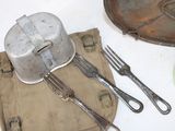 a plate, fork, knife, and pan on the table