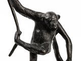 statue of a monkey holding a stick on a white background