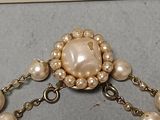 a picture of a brooch with pearls on it