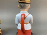 two figurines of a man and a woman dressed in uniforms
